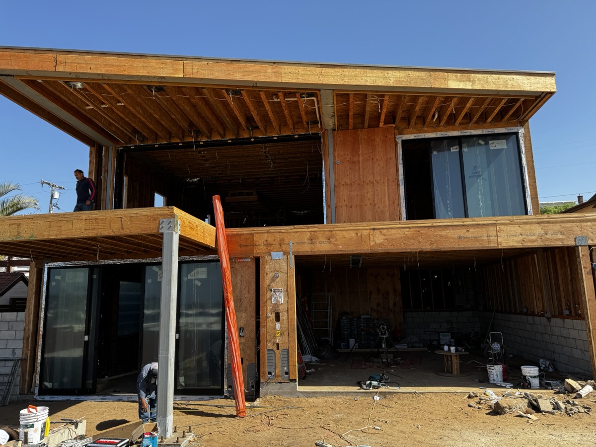 Two-story home addition framing with glass doors